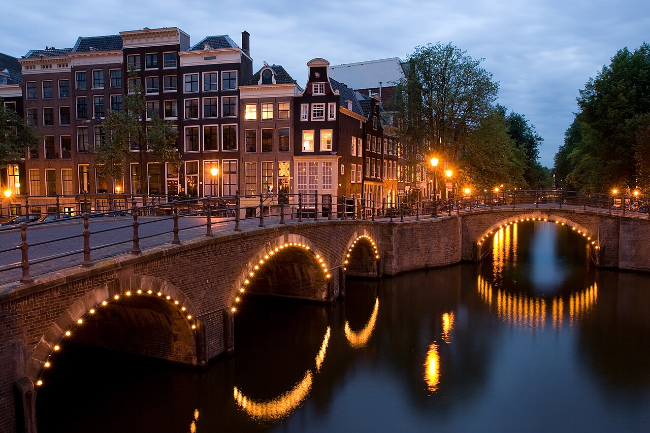 Amsterdam Keizersgracht canal bridges lit up at dusk